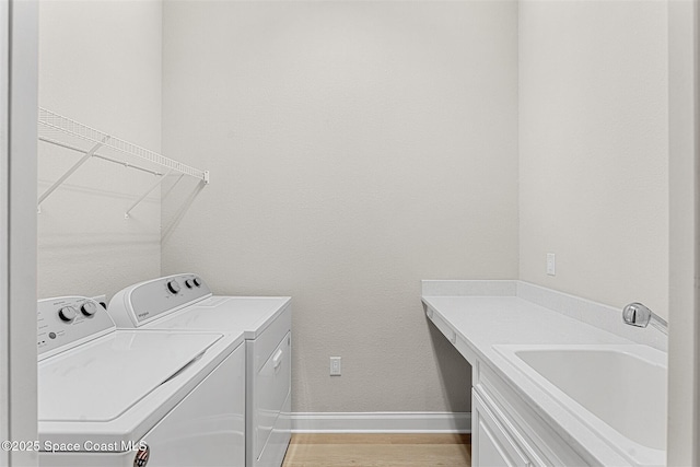 laundry area featuring sink, independent washer and dryer, and light wood-type flooring