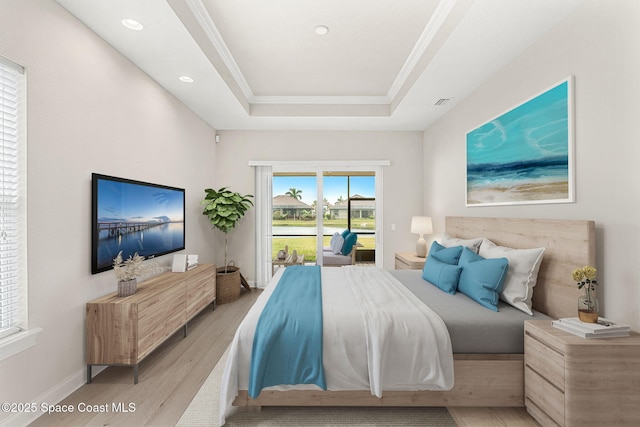 bedroom featuring a raised ceiling, crown molding, access to exterior, and light hardwood / wood-style flooring