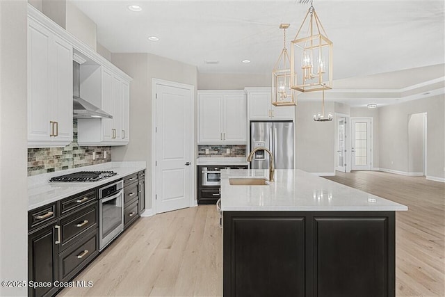 kitchen featuring white cabinetry, appliances with stainless steel finishes, sink, and pendant lighting