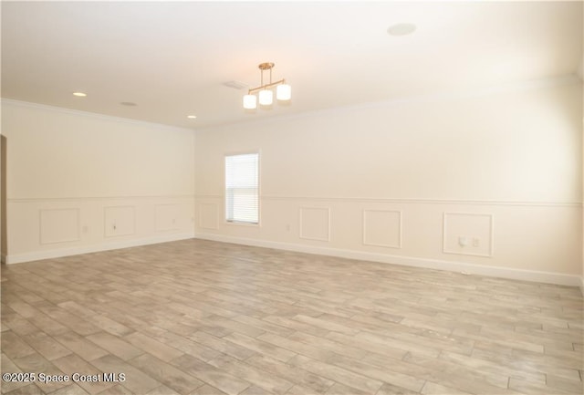 empty room featuring crown molding and light wood-type flooring