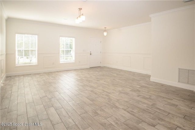 spare room with crown molding and light hardwood / wood-style flooring