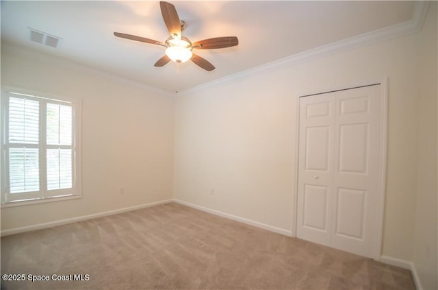 carpeted empty room with crown molding and ceiling fan