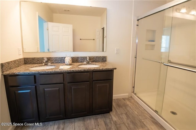 bathroom featuring hardwood / wood-style flooring, vanity, and a shower with door