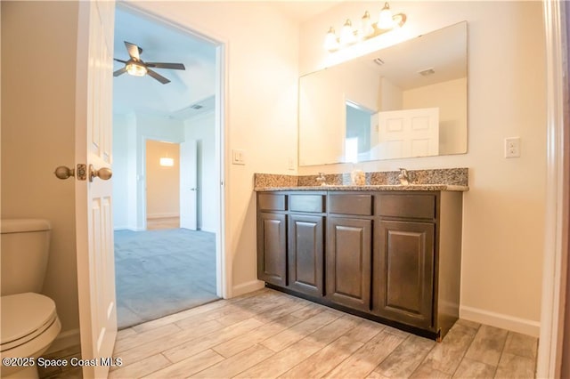 bathroom featuring vanity, ceiling fan, and toilet