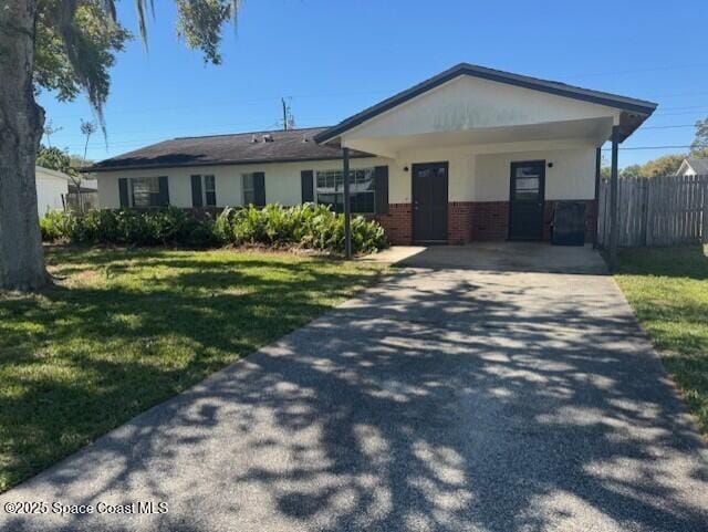 ranch-style home with driveway, a front lawn, an attached carport, fence, and brick siding