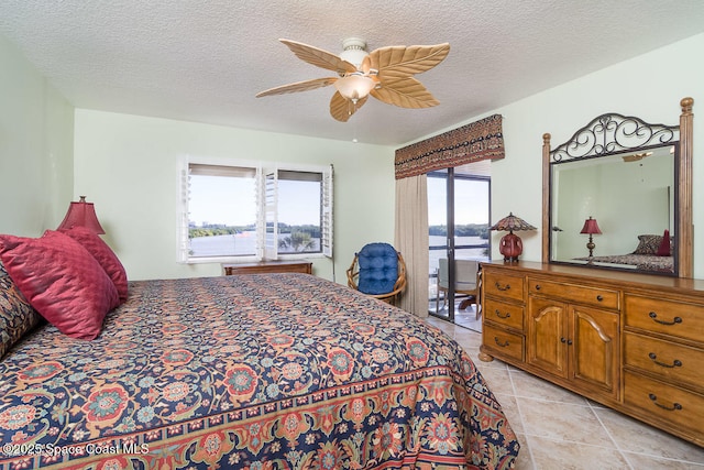 bedroom featuring ceiling fan, a textured ceiling, and light tile patterned floors