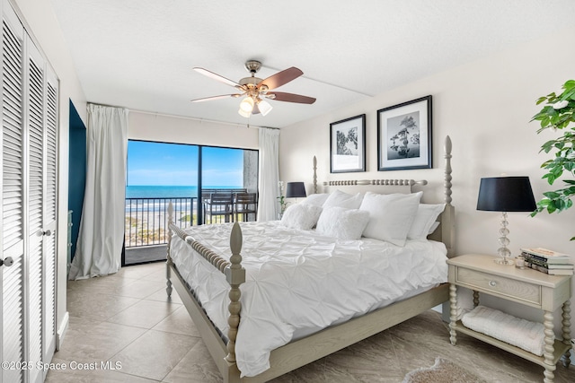 bedroom featuring a water view, ceiling fan, access to exterior, and light tile patterned floors