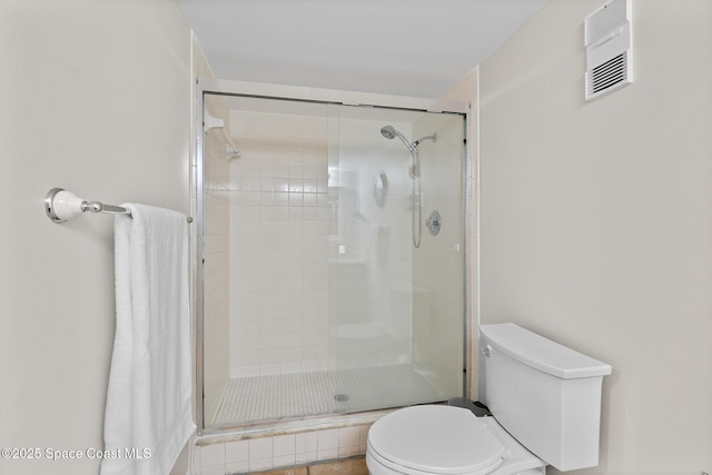 bathroom featuring walk in shower and toilet