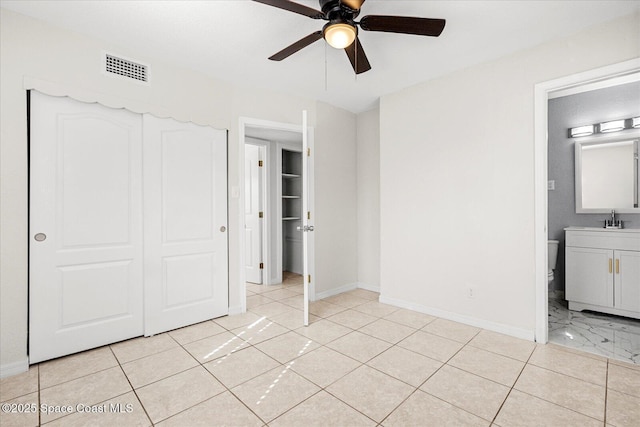 unfurnished bedroom with ensuite bath, sink, ceiling fan, and a closet