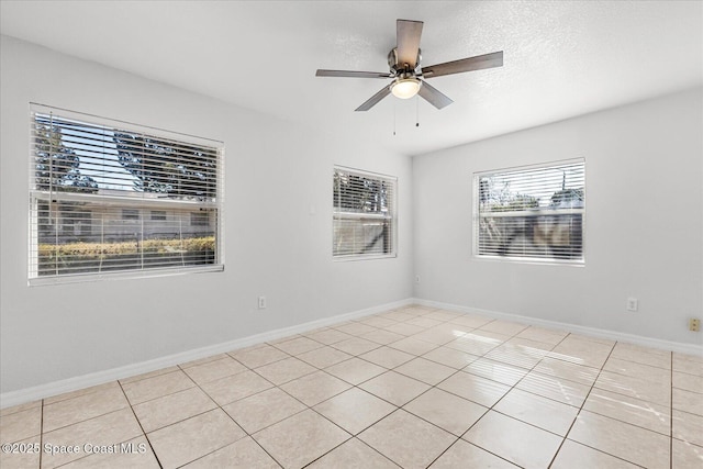 empty room with light tile patterned flooring, a textured ceiling, and ceiling fan