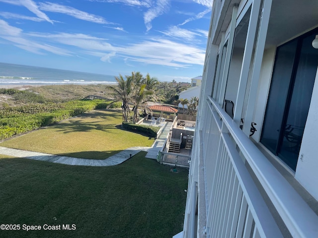 view of yard featuring a water view and a beach view