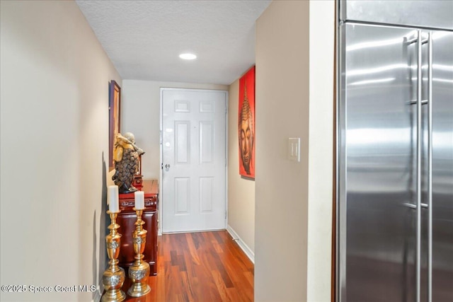 hallway featuring dark hardwood / wood-style flooring and a textured ceiling