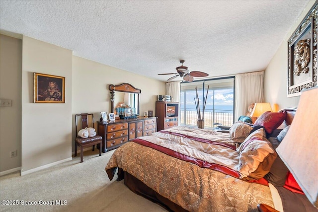 carpeted bedroom with access to exterior, a textured ceiling, and ceiling fan