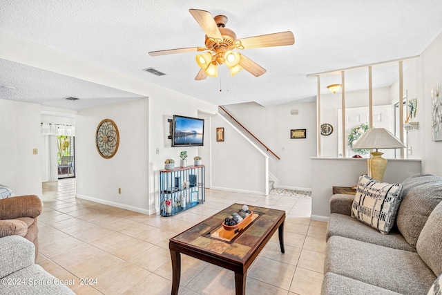 living room with light tile patterned floors, a textured ceiling, and ceiling fan