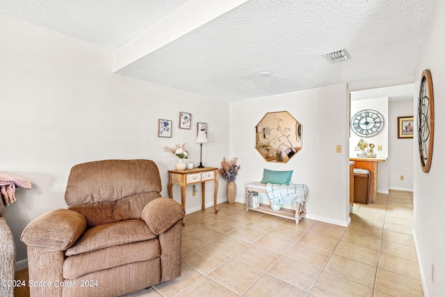 living area featuring light tile patterned floors and a textured ceiling