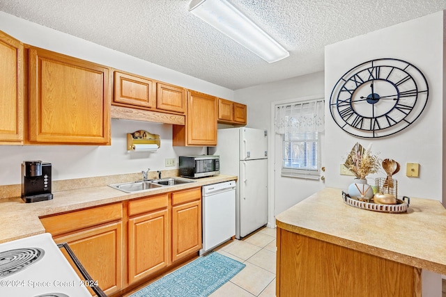 kitchen with sink, light tile patterned floors, a textured ceiling, and white appliances