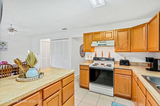 kitchen with sink, a textured ceiling, light tile patterned floors, ceiling fan, and white range with electric stovetop