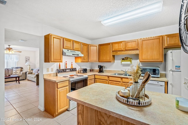 kitchen featuring light tile patterned floors, white appliances, sink, and a textured ceiling