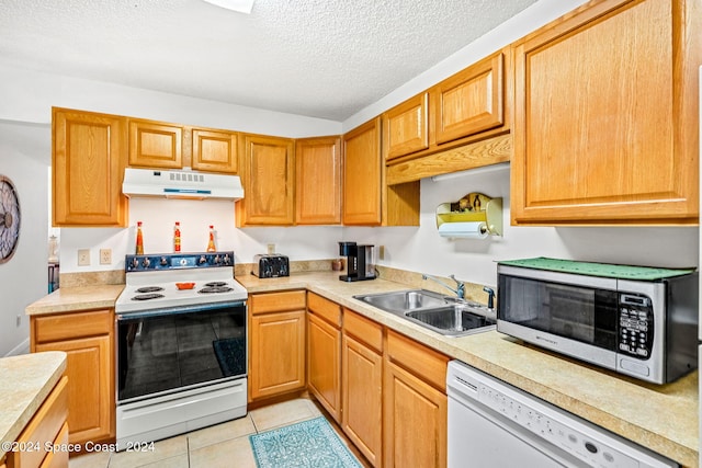 kitchen with sink, light tile patterned floors, a textured ceiling, and white appliances