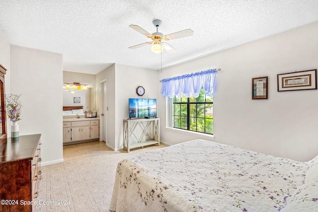 bedroom with connected bathroom, a textured ceiling, ceiling fan, and light tile patterned floors