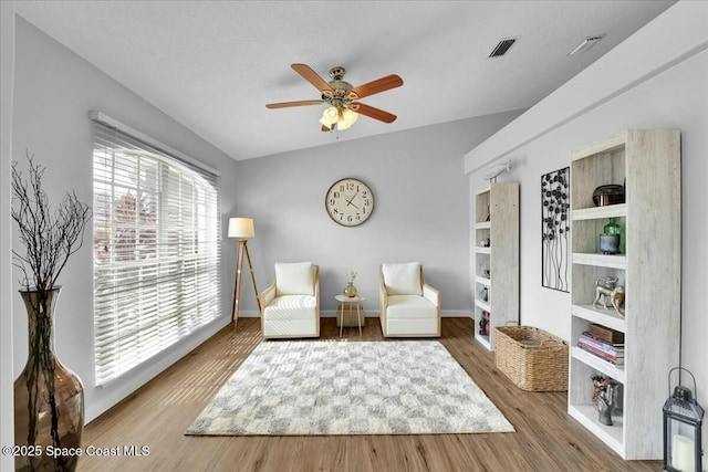 sitting room with hardwood / wood-style flooring, a textured ceiling, and ceiling fan