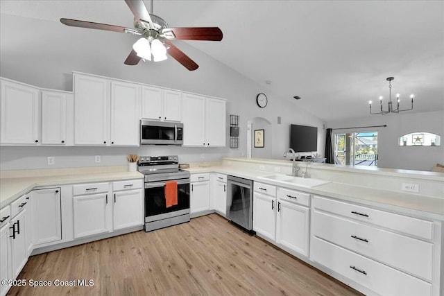 kitchen with sink, light hardwood / wood-style flooring, appliances with stainless steel finishes, white cabinetry, and vaulted ceiling