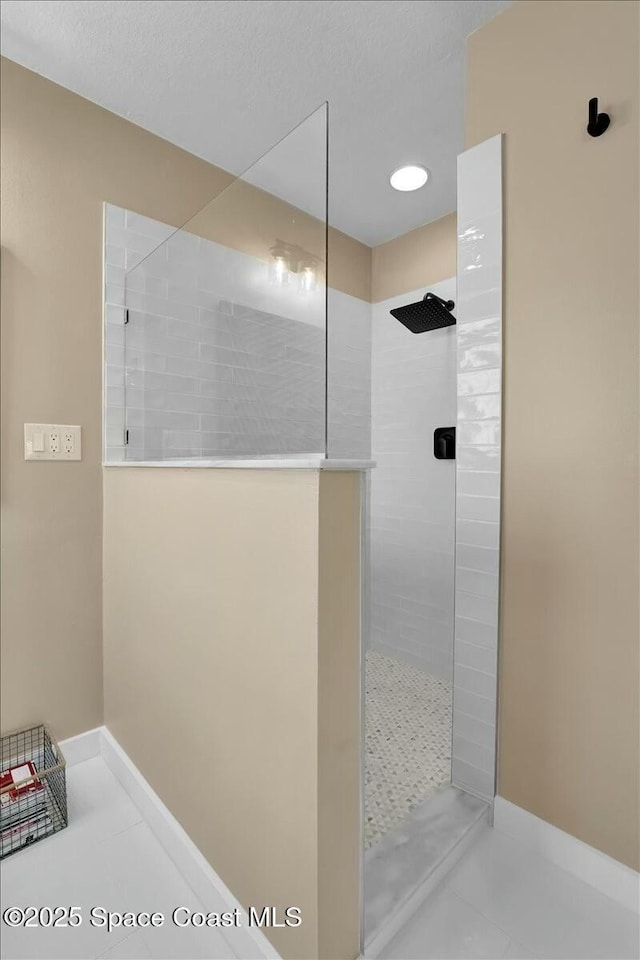 bathroom featuring tiled shower and tile patterned flooring