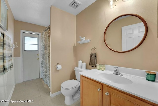 bathroom with tile patterned flooring, vanity, and toilet