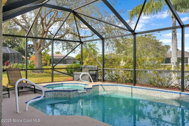 view of pool featuring an in ground hot tub, glass enclosure, and a patio