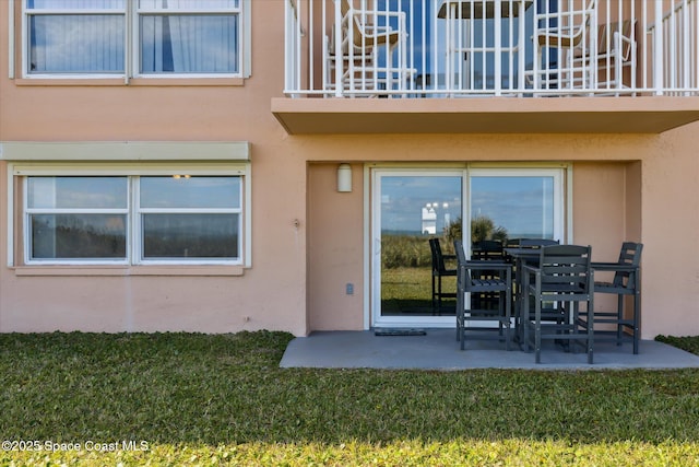 property entrance with a yard and a patio area