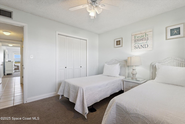 carpeted bedroom featuring ceiling fan, a closet, and a textured ceiling