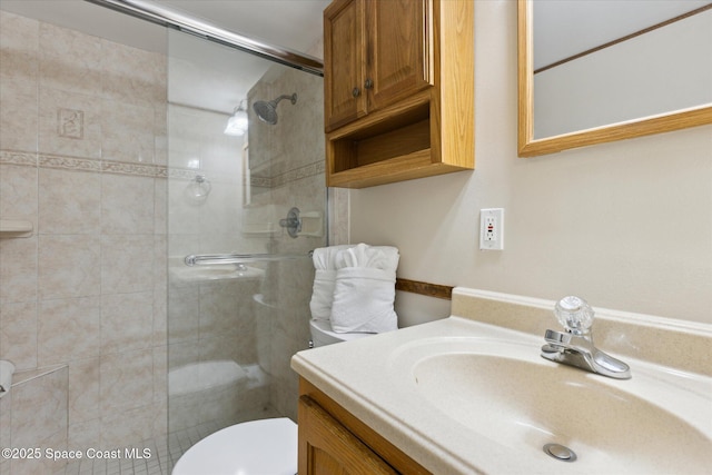 bathroom featuring vanity, toilet, and a shower with shower door