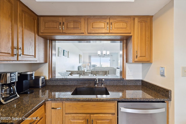 kitchen with a chandelier, dishwasher, sink, and dark stone countertops