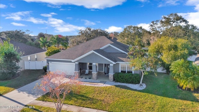 craftsman-style house featuring a garage, a front yard, and covered porch