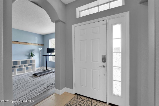 tiled foyer with a textured ceiling