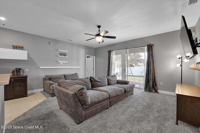 living room with light carpet, ceiling fan, and a textured ceiling