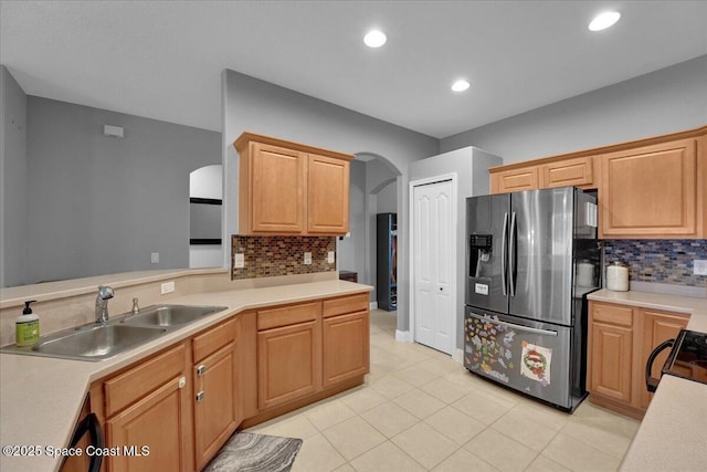 kitchen featuring sink, range, stainless steel fridge with ice dispenser, light tile patterned floors, and decorative backsplash