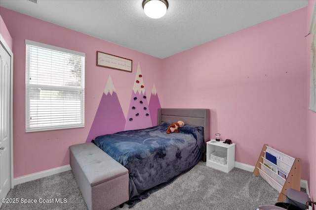 bedroom with light colored carpet and a textured ceiling