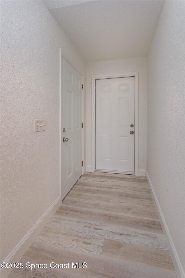 hallway with light hardwood / wood-style floors