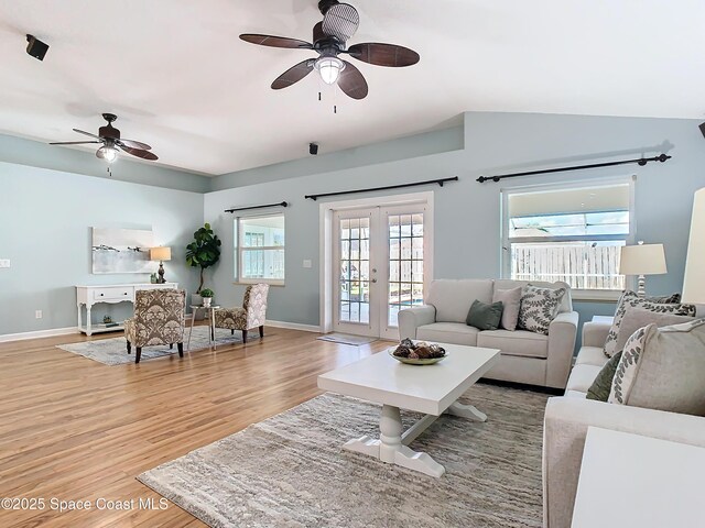 living room with lofted ceiling, hardwood / wood-style floors, ceiling fan, and french doors