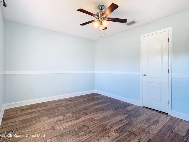 empty room featuring dark wood-type flooring and ceiling fan