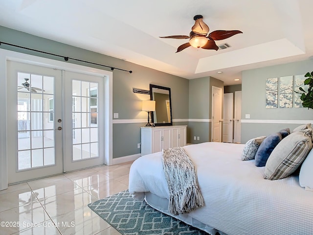 bedroom with ceiling fan, access to exterior, a tray ceiling, light tile patterned flooring, and french doors