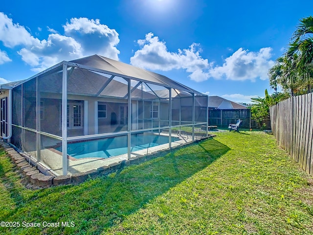 view of swimming pool with a lanai and a yard