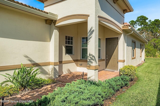 entrance to property with a lawn