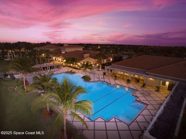 pool at dusk featuring a patio area