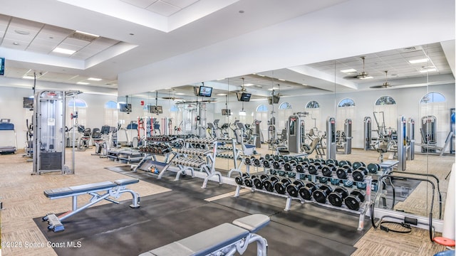 gym with a paneled ceiling and a tray ceiling