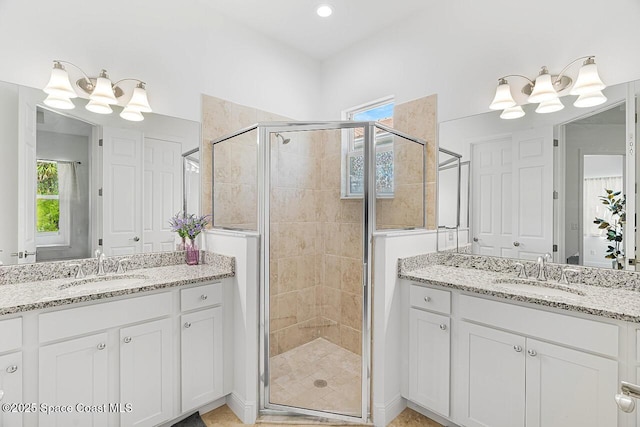 bathroom with plenty of natural light, an enclosed shower, and vanity