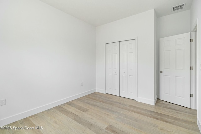 unfurnished bedroom featuring a closet and light hardwood / wood-style flooring