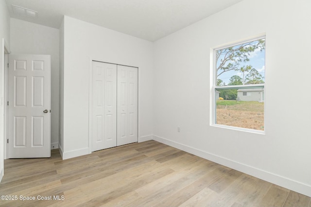 unfurnished bedroom featuring light hardwood / wood-style floors and a closet