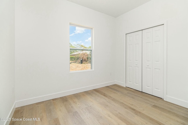 unfurnished bedroom featuring light hardwood / wood-style floors and a closet